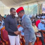 Kimilili MP Didmus Barasa and Nairobi Senator Edwin Sifuna shake hands during Mzee Patrick Wangamati’s burial ceremony as mourners and political leaders gather under a tent in Bungoma County.