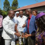 Kakamega Governor Fernandes Barasa, dressed in a white suit, greets residents while accompanied by local leaders after a church service in Lugari, Kakamega County.