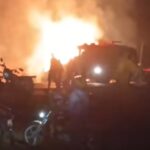 Nighttime scene showing bystanders near a blazing fire following a collision of two oil tankers in Turbo.