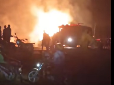 Nighttime scene showing bystanders near a blazing fire following a collision of two oil tankers in Turbo.