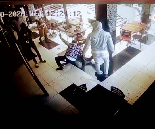 CCTV footage of several men surrounding and confronting a person inside a restaurant at Western Mall in Kisumu, with one individual on the ground during the incident.