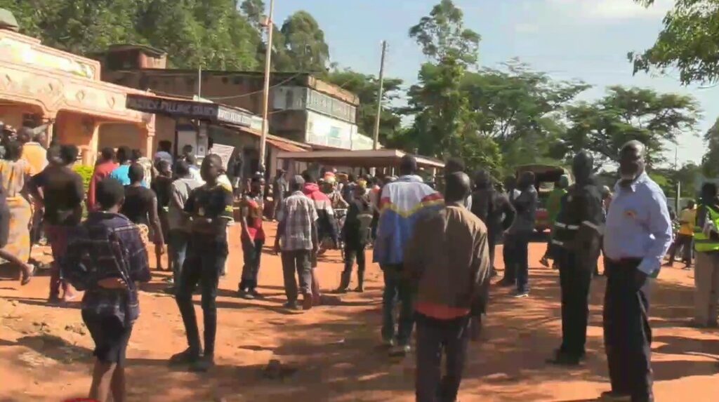 A crowd of people standing outside a building in Sang’alo, believed to be Club Solutions, after an early morning attack, with onlookers and security personnel at the scene.