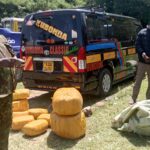 Police officers stand beside a black public service van after intercepting it at Lumakanda Junction. Several yellow-wrapped bales of cannabis sativa and green sacks containing the drugs are displayed on the ground following a Sh3 million narcotics seizure.